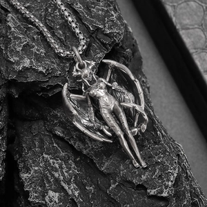 Macro detail of Gothic succubus devil wings pendant on vintage silver box chain