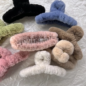 Vue à plat de pinces à cheveux en peluche douce en plusieurs couleurs sur fond blanc