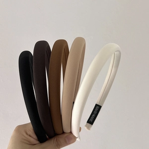 Set of five padded twill fabric headbands in neutral earthy tones with handmade labels
