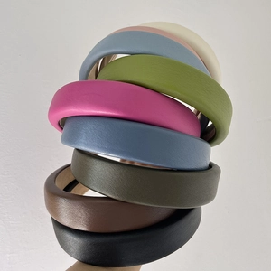 Detailed stack of multi-colored thick faux leather headbands in retro padded style