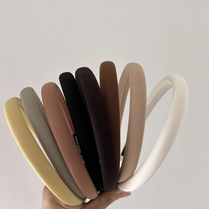 Detail showing various earth-toned padded headbands with distinct ribbed fabric texture