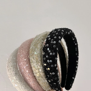 Gros plan de serre-têtes en tweed avec paillettes en noir, beige, rose et blanc