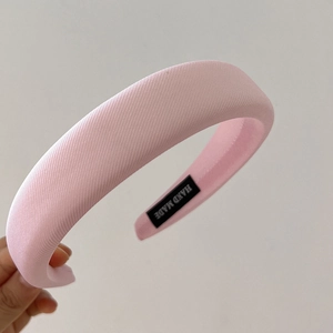 Detail of pink padded sponge headband with woven texture and handmade interior label