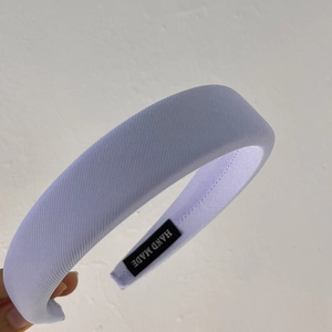 Close-up of light blue sponge headband with twill fabric and handmade woven label