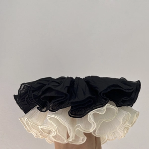 Detail of layered chiffon scrunchies in black and beige with soft pleated texture