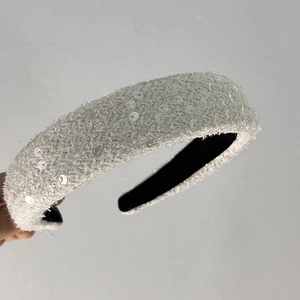 Détail du serre-tête en tweed avec paillettes brillantes et doublure intérieure noire