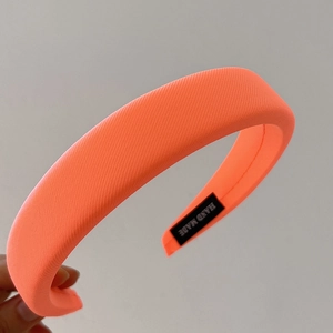 Detailed macro view of the bright orange sponge headband with a hand made woven label