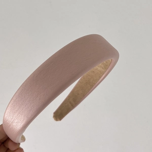 Close-up of pink padded headband with leather texture design for a chic voluminous look