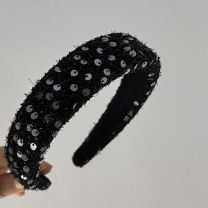 Détail d'un serre-tête en velours noir avec paillettes argentées scintillantes à bord large