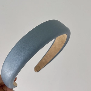 Detailed view of light blue faux leather headband with sponge padding and litchi texture