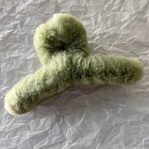 Vue détaillée de la pince à cheveux en peluche verte avec texture en fausse fourrure