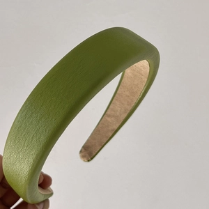 Detail of grass green padded headband with textured leather finish and soft inner fabric