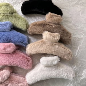 Top view of various colorful plush faux fur hair claw clips on a soft grey backdrop