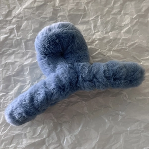 Gros plan d'une grande pince à cheveux bleue en fausse fourrure douce pour l'hiver