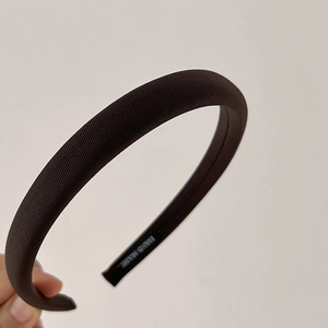 Detail showing deep brown twill fabric texture and hand made label on sponge headband