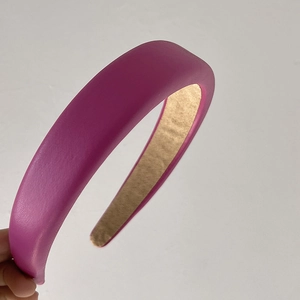 Detail of pink-purple padded headband with litchi grain faux leather texture
