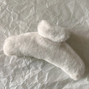 Detailed view of large cream plush hair claw clip with soft faux fur texture for women