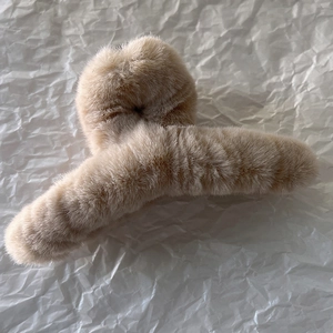 Grosse pince à cheveux en peluche marron clair avec une texture douce et une finition mate