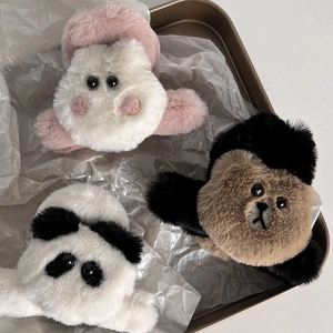Dettaglio di fermacelli in peluche a forma di panda e coniglio in un vassoio oro