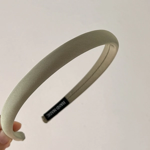 Detail of light green padded sponge headband with twill fabric and handmade label