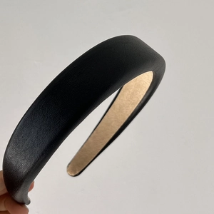 Detailed side view of thick black leather headband with contrast lining and rich texture