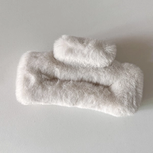 Détail de la pince à cheveux carrée en peluche beige avec texture douce en fausse fourrure