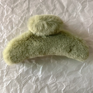 Detail of the soft faux fur texture and grass green color of the large hair claw clip