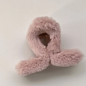 Détail d'une pince à cheveux en peluche rose avec texture douce et prise intérieure ferme
