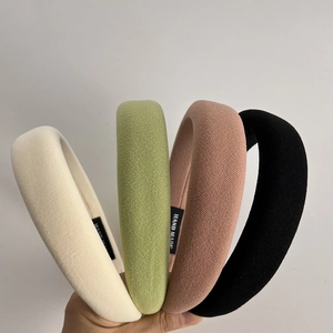 Set of four padded sponge headbands in cream, green, pink, and black textured fabric