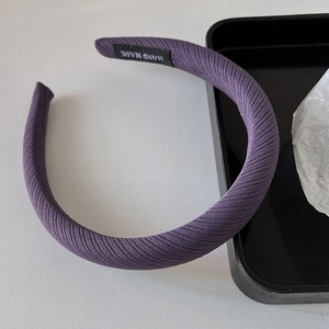 Vue détaillée du serre-tête tricoté violet avec étiquette artisanale Hand Made