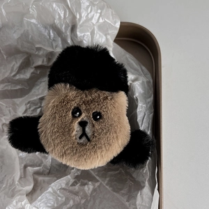 Dettaglio della molletta per capelli a forma di orsetto di peluche su vassoio dorato