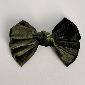Détail du tissu en velours vert foncé élégant sur une grande barrette à nœud français