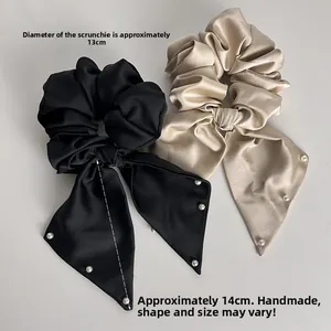 Detailed view of satin bow scrunchies with faux pearls, measuring 13cm in diameter