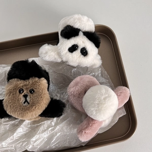 Dettaglio delle mollette per capelli in peluche a forma di panda e orso con finta pelliccia