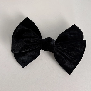 Gros plan sur la barrette nœud en velours noir avec texture double couche et fini mat