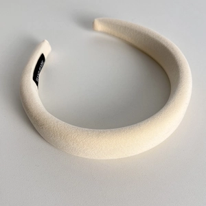 Detailed view of handmade padded velvet headband with high crown and brand label