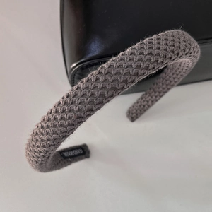 Macro shot of grey knitted headband showing textured fabric and hand made label detail