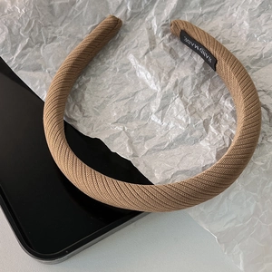 Détail du bandeau en tricot marron avec étiquette faite main et texture nervurée