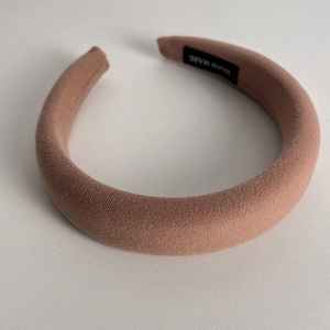 Detail of soft sponge headband in dusty pink with handmade label and fabric texture