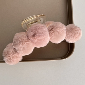 Detailed view of pink plush hair claw clip with faux rabbit fur balls and acrylic base