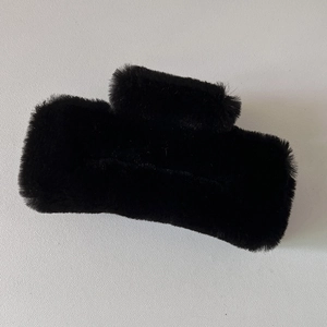 Détail de la matière pelucheuse noire sur la surface de la pince à cheveux carrée