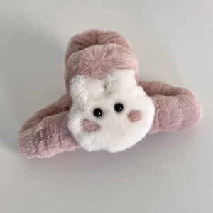 Détail d'une pince à cheveux en peluche rose avec un décor de lapin blanc mignon