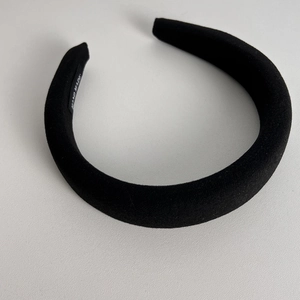 Detail of black velvet padded headband featuring a hand made woven label inside