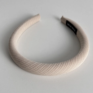 Close-up of beige twill fabric padded headband with a hand-made textile label inside