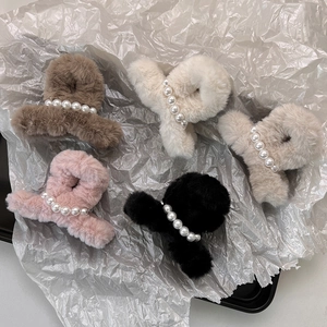 Dettaglio di fermagli per capelli in peluche con perle in marrone, bianco, beige e rosa