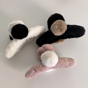 Vue détaillée de trois pinces à cheveux en fausse fourrure pelucheuse blanche et noire