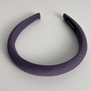 Close-up of handmade purple twill sponge headband with ribbed texture and interior label