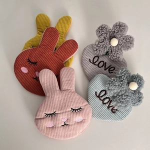 Detailed close-up of corduroy rabbit and heart hair clips with cute floral embroidery