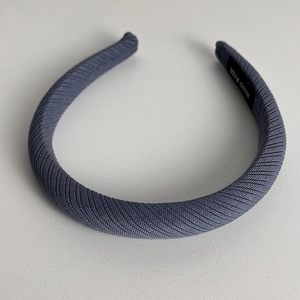 Detail of grey-blue twill fabric headband with a woven HAND MADE craft label