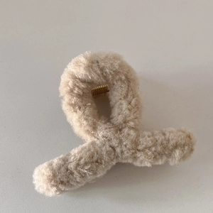 Détail de la pince à cheveux en peluche crème avec fourrure et ressort doré